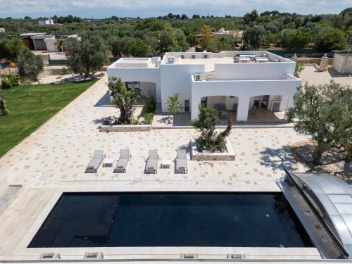 an aerial view of a white house with a swimming pool at La Dimora della Luna - Country Home Suite & Spa in Carovigno