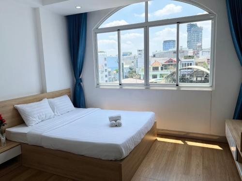 a bedroom with a bed and a large window at Home Away Ky Con - Serviced Apartment in Ho Chi Minh City