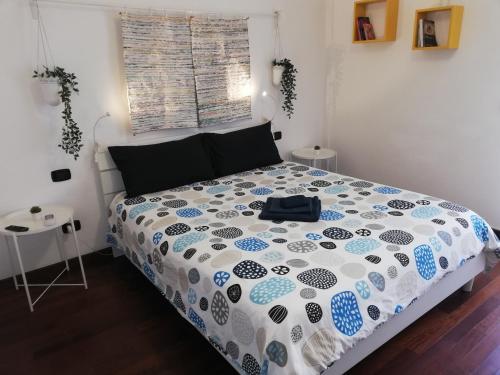 a bedroom with a bed with a blue and white comforter at De Rossi Holiday in Bari