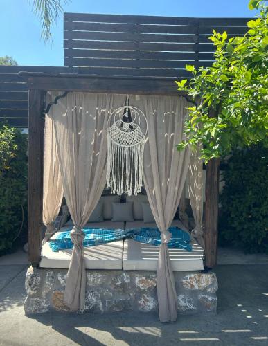 a bed with curtains and a chandelier at Aithonas Villa in Archangelos