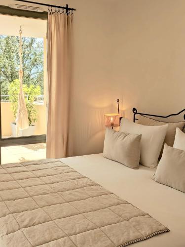 une chambre avec un grand lit blanc avec une fenêtre dans l'établissement ALLURA GOLF APPARTEMENT, à Saumane-de-Vaucluse