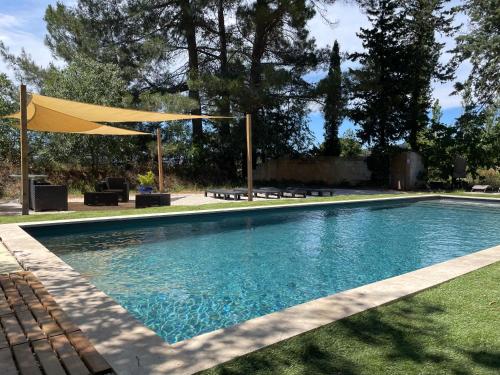 - une piscine avec un parasol jaune dans la cour dans l'établissement Oustau Aix, à Aix-en-Provence