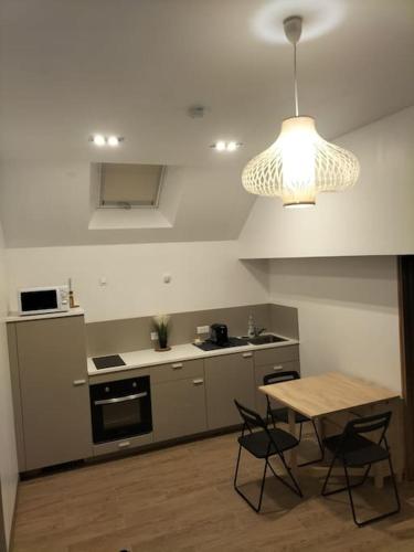 une cuisine avec une table, des chaises et une lampe dans l'établissement Maison individuelle indépendante neuve 24-24h, à Morigny-Champigny