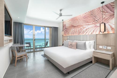 a bedroom with a large white bed and a desk at Royalton CHIC Antigua, An Autograph Collection All-Inclusive Resort - Adults Only in Saint Johnʼs
