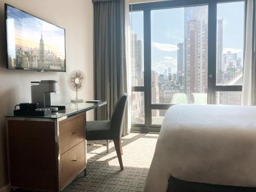 a hotel room with a bed and a desk and a window at Executive Hotel Le Soleil New York in New York