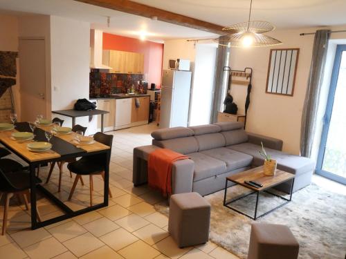 un salon avec un canapé et une table dans l'établissement Au Gré des Saisons - Vulcania & Lemptégy, à Pontgibaud