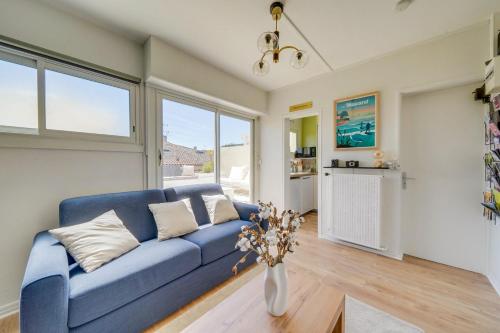 - un canapé bleu dans le salon avec fenêtres dans l'établissement Appartement central - Toit-terrasse, à Libourne