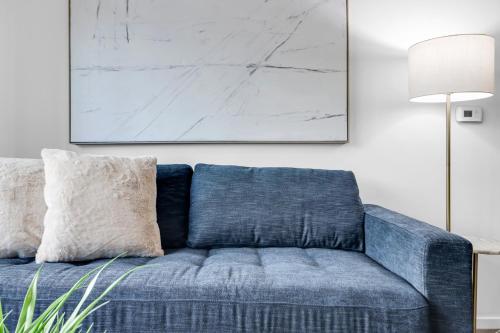 a blue couch in a living room with a painting on the wall at The Nomad Roosevelt in Phoenix