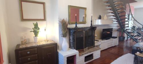 a living room with a fireplace and a staircase at Villa Seven Malo PENTHOUSE in Dunkerque