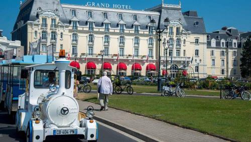 a train is parked in front of a building at Studio moderne en bord de mer in Cabourg