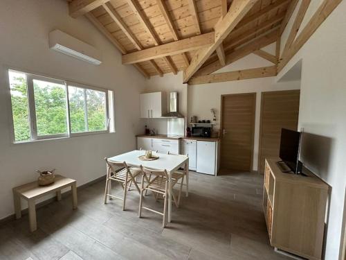 une cuisine avec une table et des chaises dans une pièce dans l'établissement apparement 6 personnes avec jardin, à Ondres