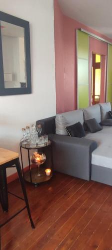 a living room with a couch and a table at Villa Seven Malo PENTHOUSE in Dunkerque