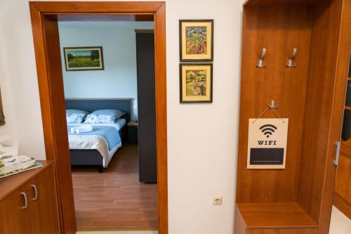a bedroom with a bed and a door with a sign at Apartment Lucija in Široki Brijeg
