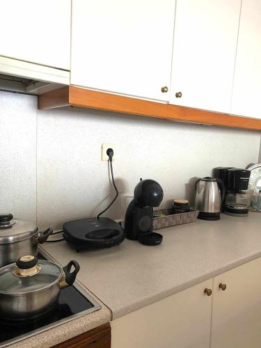 a kitchen counter with a stove with a pot on it at Mare Mia in Loutraki