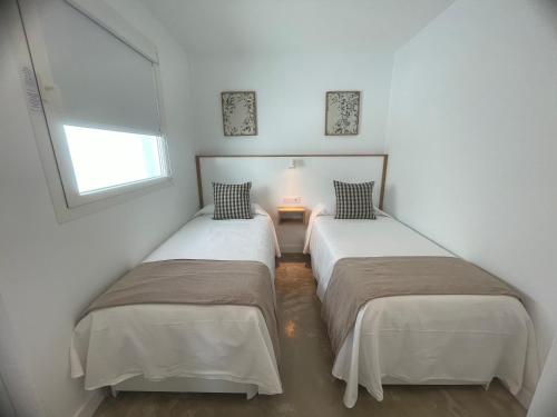 two beds in a small room with a window at Ventana del Nublo 2-D in Tejeda