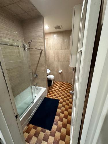 a bathroom with a shower and a tub and a toilet at Hudson Yard 408 in New York