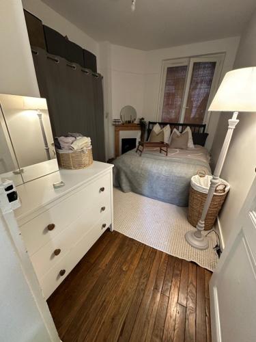- une chambre avec un lit et une commode avec une lampe dans l'établissement Cosy proche Tour Eiffel, à Paris