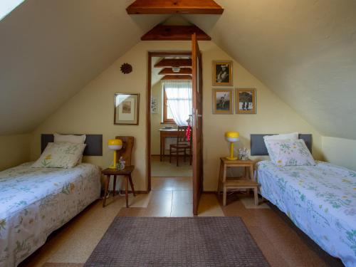 a attic room with two beds and a mirror at Lipowy dom in Piecki