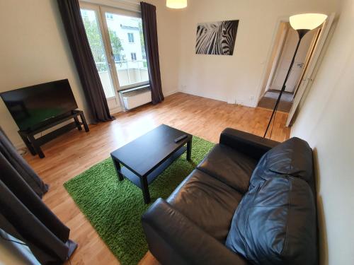 a living room with a leather couch and a coffee table at Home Inn DRV278 in Stockholm