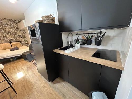 une petite cuisine avec un évier et un micro-ondes dans l'établissement Fully renovated studio for 2, à Paris