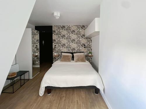 une chambre avec un lit et un mur dans l'établissement Fully renovated studio for 2, à Paris