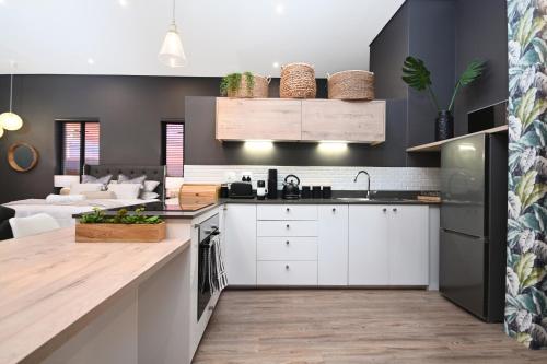 a kitchen with white cabinets and a living room at 309 on Titanium in Cape Town