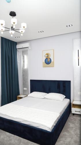 a bedroom with a large bed with a blue headboard at Nazar Hotel & hostel in Türkistan