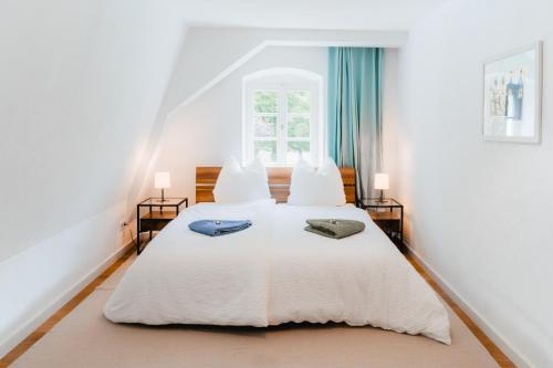 a bedroom with a white bed with two towels on it at Inselapartment in Altstadtnähe in Regensburg