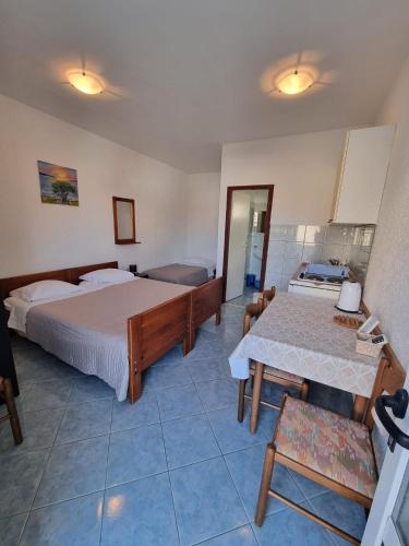 a hotel room with a bed and a table and chairs at Apartmani Bada in Pakoštane