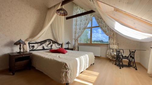 a bedroom with a bed and a large window at Pērles in Durbe