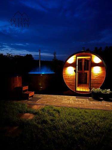 a circular building with lights on it at night at oBłędne Chaty in Wünschelburg