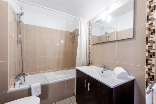 a bathroom with a sink and a tub and a toilet at Solgarve in Quarteira