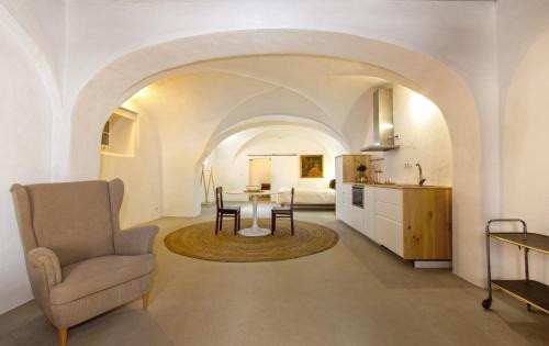 a kitchen and living room with a table and a chair at Casa Ancha in Beja
