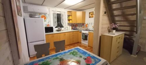 a small kitchen with a table and a refrigerator at Domek na Mazurach. in Dłużek