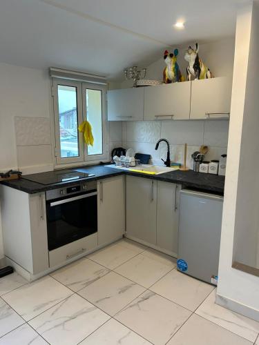 une cuisine avec des armoires blanches et des comptoirs noirs dans l'établissement 146madeleine, à Nice