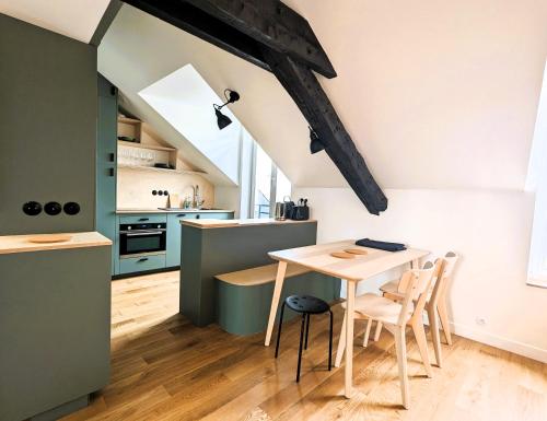 une cuisine et une salle à manger avec une table et des chaises dans l'établissement Appart sur les toits de Paris - Marais, à Paris