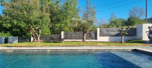 une piscine devant une maison avec des arbres dans l'établissement La FANGADE, à Mirabeau