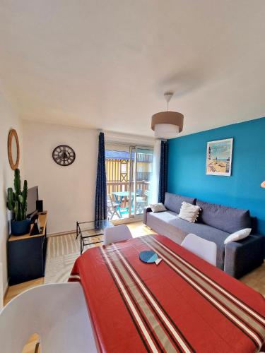 un salon avec un canapé et une table dans l'établissement Côté Plage & Balcon, à Cabourg