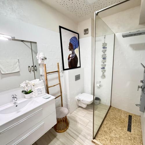 a bathroom with a shower and a sink and a toilet at White Tower Mamaia - Private Apartment in Mamaia