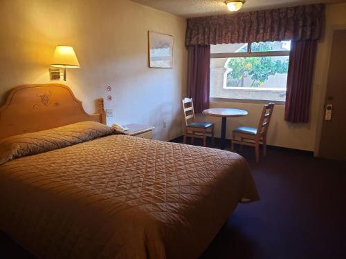 a hotel room with a bed and a table and a window at La Villa de Zaragoza in Tijuana