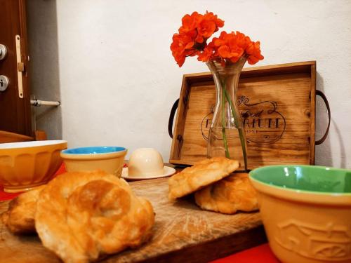 a table with a vase of flowers and some pastries at Appartamento rustico con giardino e parcheggio gratuito in Imperia