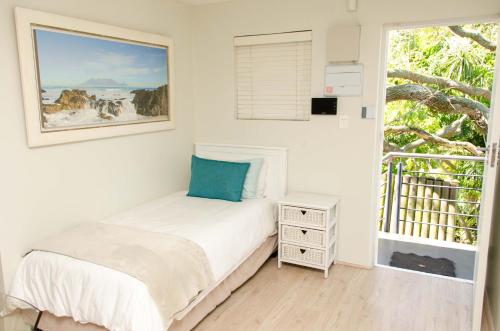 a small bedroom with a bed and a window at Art and Accommodation Guesthouse in Cape Town