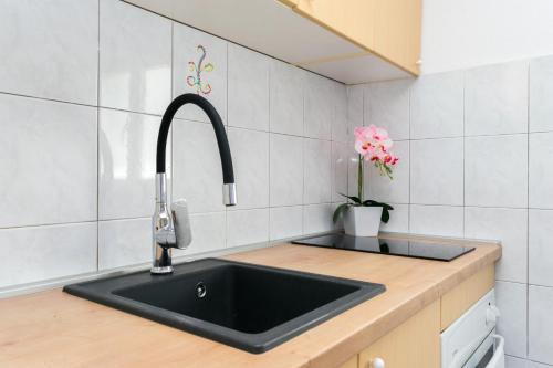 a kitchen with a black sink and a vase of flowers at Apartment Šimunović in Drače