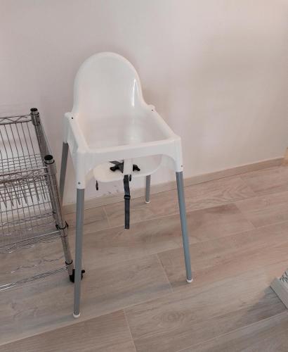 a white chair sitting next to a shopping cart at La Chicca Maison in Vercurago