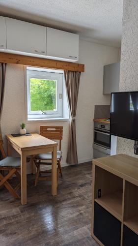 une cuisine avec une table et une table et une fenêtre dans l'établissement Studio avec linge de maison fourni et tout équipé aux pieds des pistes, à Villard-de-Lans