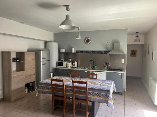 une cuisine avec une table et des chaises dans une cuisine dans l'établissement Maison lumineuse à 100 m du lac de Lacanau, à Lacanau
