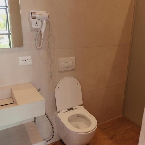 a bathroom with a toilet and a phone on the wall at Dia Mare Deluxe in Vlorë