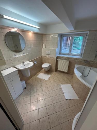 a bathroom with a sink and a tub and a toilet at Apartmány u Kubíků in Hradec Králové