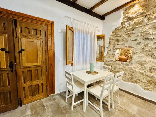 Casita Marinera في بينييسكولا: طاولة بيضاء وكراسي في غرفة بجدار حجري