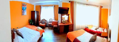 a bedroom with two beds and a television in it at Hotel Avenida in La Paz